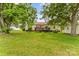 Expansive backyard with lush green grass, mature trees, a wooden deck, and a storage shed at 3951 Springs Rd, Conover, NC 28613