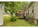 Backyard view featuring a wooden deck, mature trees, and vibrant greenery at 3951 Springs Rd, Conover, NC 28613