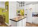 Bright kitchen with white cabinetry, tiled countertops, stainless steel appliances, and a view into the living area at 3951 Springs Rd, Conover, NC 28613
