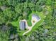 Aerial perspective showcases a modern home and three bay garage nestled in a lush, green forest at 6620 Old Concord Rd, Salisbury, NC 28146