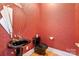 Stylish powder room with unique mirror, black sink and toilet, and red textured walls at 6620 Old Concord Rd, Salisbury, NC 28146