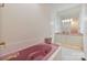 Bathroom featuring a unique pink bathtub and sink and white cabinets at 6620 Old Concord Rd, Salisbury, NC 28146