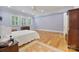 Bright bedroom with wood floors, three windows, and blue walls and white ceiling at 6620 Old Concord Rd, Salisbury, NC 28146