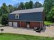 Rear exterior of a brick home featuring a dark metal roof, patio, and well-maintained lawn at 6620 Old Concord Rd, Salisbury, NC 28146