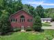 Charming red brick house with a gray metal roof, surrounded by mature trees and a well-manicured lawn at 6620 Old Concord Rd, Salisbury, NC 28146