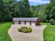 Aerial view of four-car garage with lush green landscaping, beautiful trees, and a metal roof at 6620 Old Concord Rd, Salisbury, NC 28146