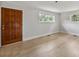 Bright living room featuring light hardwood floors, two windows, and a wooden front door at 6620 Old Concord Rd, Salisbury, NC 28146