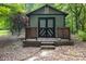 Rustic outdoor storage shed with a decorative door and wooden stairs at 6620 Old Concord Rd, Salisbury, NC 28146