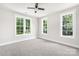 A bedroom with three white windows allowing natural light and a ceiling fan at 2627 Ashbourne Dr, Gastonia, NC 28056