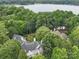 Aerial view of a lakefront home with lush landscaping at 4409 Solemn Point Ln, Charlotte, NC 28216