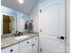 Bathroom with granite countertop, white cabinets, and black fixtures at 4409 Solemn Point Ln, Charlotte, NC 28216