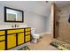 Bright bathroom with yellow vanity, shower, and tile floor at 4409 Solemn Point Ln, Charlotte, NC 28216