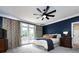Main bedroom with blue walls, king-size bed, and access to a balcony at 4409 Solemn Point Ln, Charlotte, NC 28216