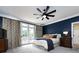 Spacious bedroom with navy blue walls, a ceiling fan, and French doors leading to a deck at 4409 Solemn Point Ln, Charlotte, NC 28216