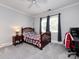 Bedroom with double bed, window, and carpeted floor at 4409 Solemn Point Ln, Charlotte, NC 28216
