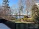 Scenic backyard view of tranquil lake and lush greenery at 4409 Solemn Point Ln, Charlotte, NC 28216