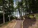 Lakefront view with a pathway and wooden chairs at 4409 Solemn Point Ln, Charlotte, NC 28216