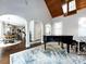 Open living space with hardwood floors, piano and views into dining area at 4409 Solemn Point Ln, Charlotte, NC 28216