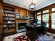 Home office with built-in bookshelves, a fireplace, and a large desk at 4409 Solemn Point Ln, Charlotte, NC 28216