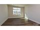 An empty bedroom with wood laminate flooring and a window offering natural light at 139 Armstrong Rd, Belmont, NC 28012