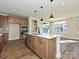 A kitchen with a center island, pendant lighting, wood cabinetry, and stainless appliances connects to a living area at 139 Armstrong Rd, Belmont, NC 28012