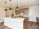 Open-concept kitchen with a center island, granite countertops, wood cabinets, stainless steel appliances, and modern pendant lighting at 139 Armstrong Rd, Belmont, NC 28012