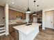 A modern kitchen features a large island with quartz countertops and pendant lighting, complemented by wood-look floors at 139 Armstrong Rd, Belmont, NC 28012