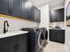 Modern laundry room with dark cabinetry, sink, countertops, and front-loading washer and dryer at 139 Armstrong Rd, Belmont, NC 28012