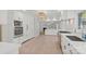 Modern kitchen with white cabinets, stainless steel appliances, and light hardwood floors at 1626 S Wendover Rd, Charlotte, NC 28211