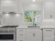 Modern kitchen features white cabinets, marble countertops, and a farmhouse sink at 1626 S Wendover Rd, Charlotte, NC 28211