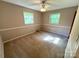 Cozy bedroom featuring soft carpeting, light-filled windows, and a ceiling fan for added comfort at 1111 S Skyland Dr, Mount Pleasant, NC 28124