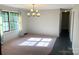 Well-lit dining room with a chandelier and a large window, blending carpet and tile flooring for a unique layout at 1111 S Skyland Dr, Mount Pleasant, NC 28124