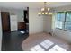Dining room showing carpet and tile flooring, adjacent to the kitchen, illuminated by a chandelier and a window at 1111 S Skyland Dr, Mount Pleasant, NC 28124