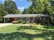 Charming brick house with a carport, complemented by a well-maintained lawn and lush landscaping at 1111 S Skyland Dr, Mount Pleasant, NC 28124