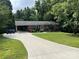 Charming brick home with blue shutters, lush landscaping, and long driveway leading to a carport at 1111 S Skyland Dr, Mount Pleasant, NC 28124