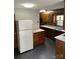 Full kitchen view featuring a white refrigerator, wood cabinets, and stainless steel sink for a functional cooking space at 1111 S Skyland Dr, Mount Pleasant, NC 28124