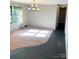An empty, carpeted living room featuring natural light and neutral paint, ready to be customized to your taste at 1111 S Skyland Dr, Mount Pleasant, NC 28124