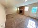 Open living room with neutral carpet and walls, featuring a charming brick fireplace at 1111 S Skyland Dr, Mount Pleasant, NC 28124