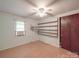 This bedroom features an air conditioner, shelving and a closet for storage and organization at 12770 Bringle Ferry Rd, Richfield, NC 28137