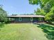 Side view of a rustic home showcasing green shutters and metal roof with a lush lawn at 12770 Bringle Ferry Rd, Richfield, NC 28137