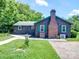 Cozy home featuring wood siding, a green roof, brick chimney, and well-maintained lawn at 12770 Bringle Ferry Rd, Richfield, NC 28137