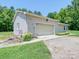 Detached garage with a wide door, adjacent to a well-kept lawn and gravel driveway at 12770 Bringle Ferry Rd, Richfield, NC 28137