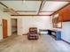Garage interior featuring wood paneling, a vintage recliner, and built-in desk area at 12770 Bringle Ferry Rd, Richfield, NC 28137