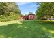 The back of the home overlooks a sprawling green lawn, bordered by trees and landscaping at 640 Davie Ave, Statesville, NC 28677