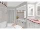 This bathroom includes a tub, shower with curtain, tile accents, and white cabinets at 640 Davie Ave, Statesville, NC 28677