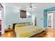 This bedroom features hardwood floors, a ceiling fan, and a yellow floral comforter at 640 Davie Ave, Statesville, NC 28677