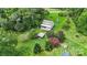 House nestled in a green landscape with a detached workshop and solar panels at 7507 Waxhaw Creek Rd, Waxhaw, NC 28173