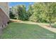 Large backyard with grassy lawn, retaining wall, and wooded area at 556 Peaceful Creek Dr, York, SC 29745