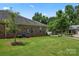 Landscaped backyard with mature trees and green grass at 6801 Cinnamon Cir, Mint Hill, NC 28227