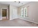 Well-lit bedroom with carpet, double window, and bathroom access at 6801 Cinnamon Cir, Mint Hill, NC 28227